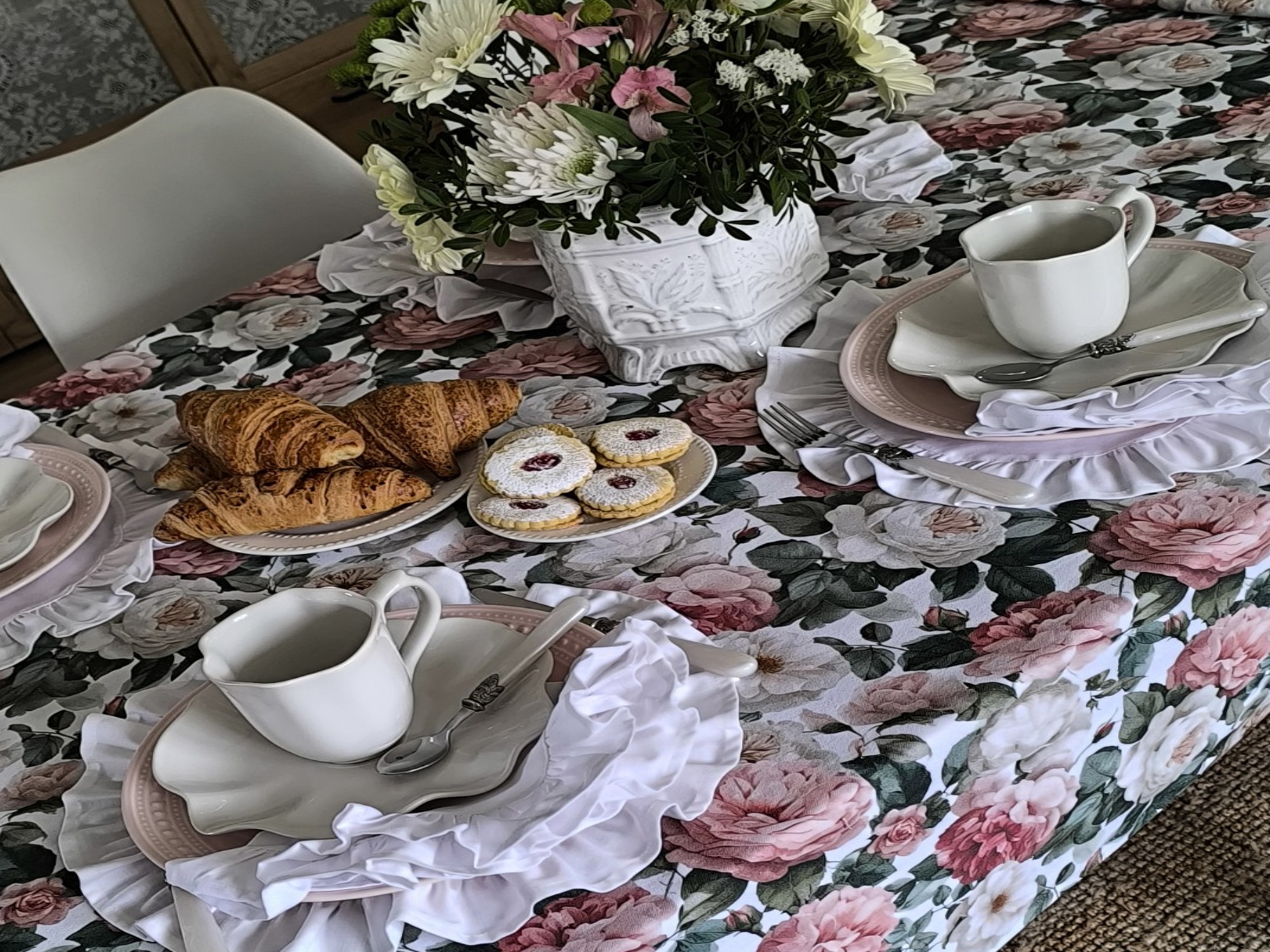 Mesa de celebração com toalha floral e apontamentos coloridos
