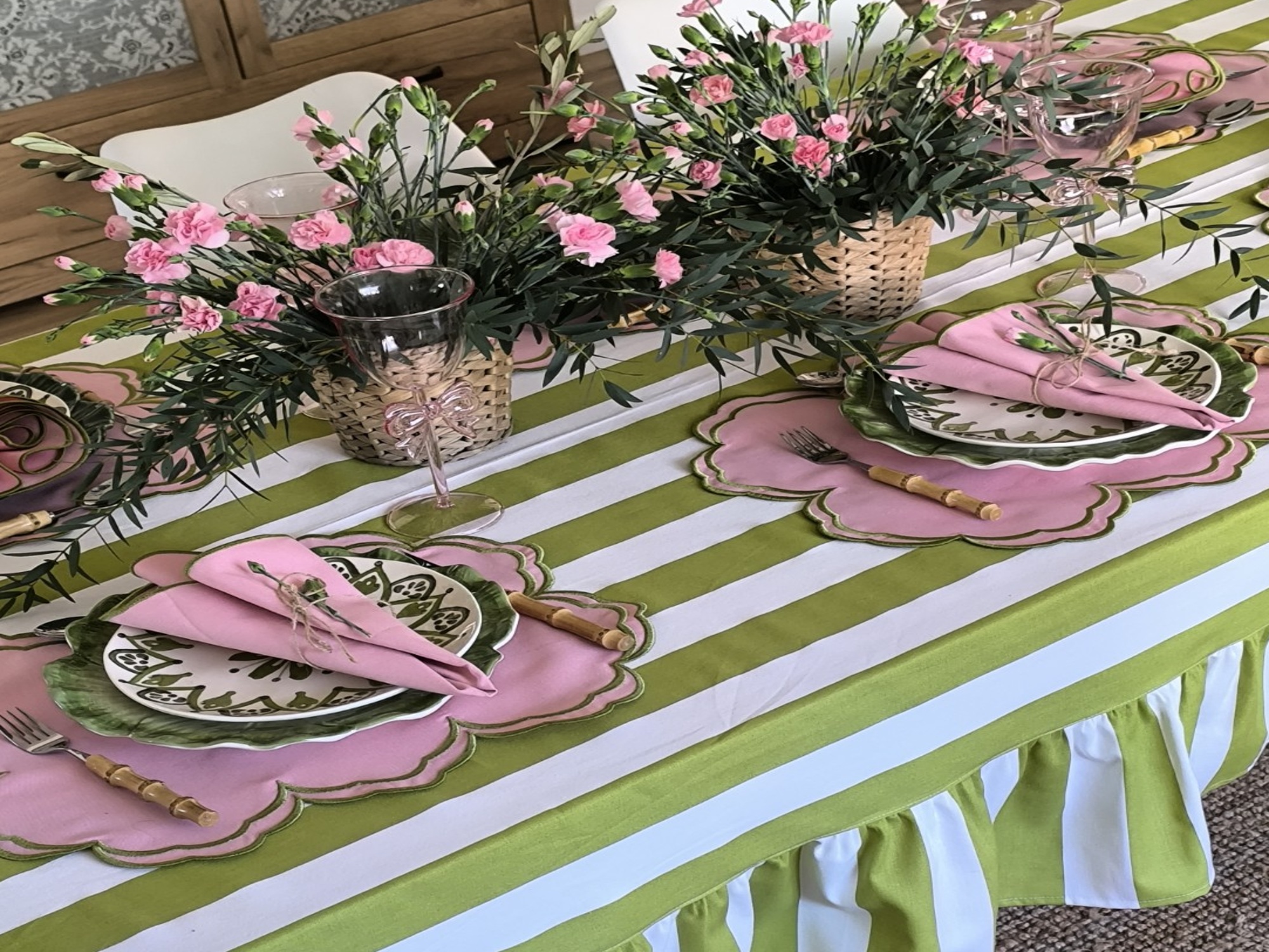 Mesa comprida com têxteis às riscas em tons rosa e verde