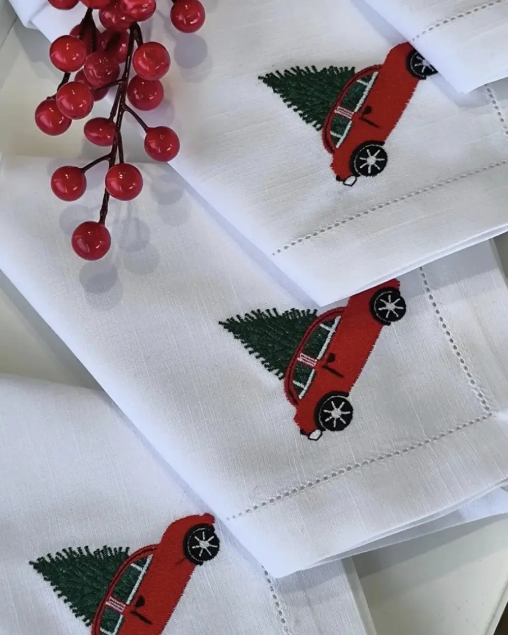 Guardanapos brancos com ponto aberto e bordado Carrinho de Natal
