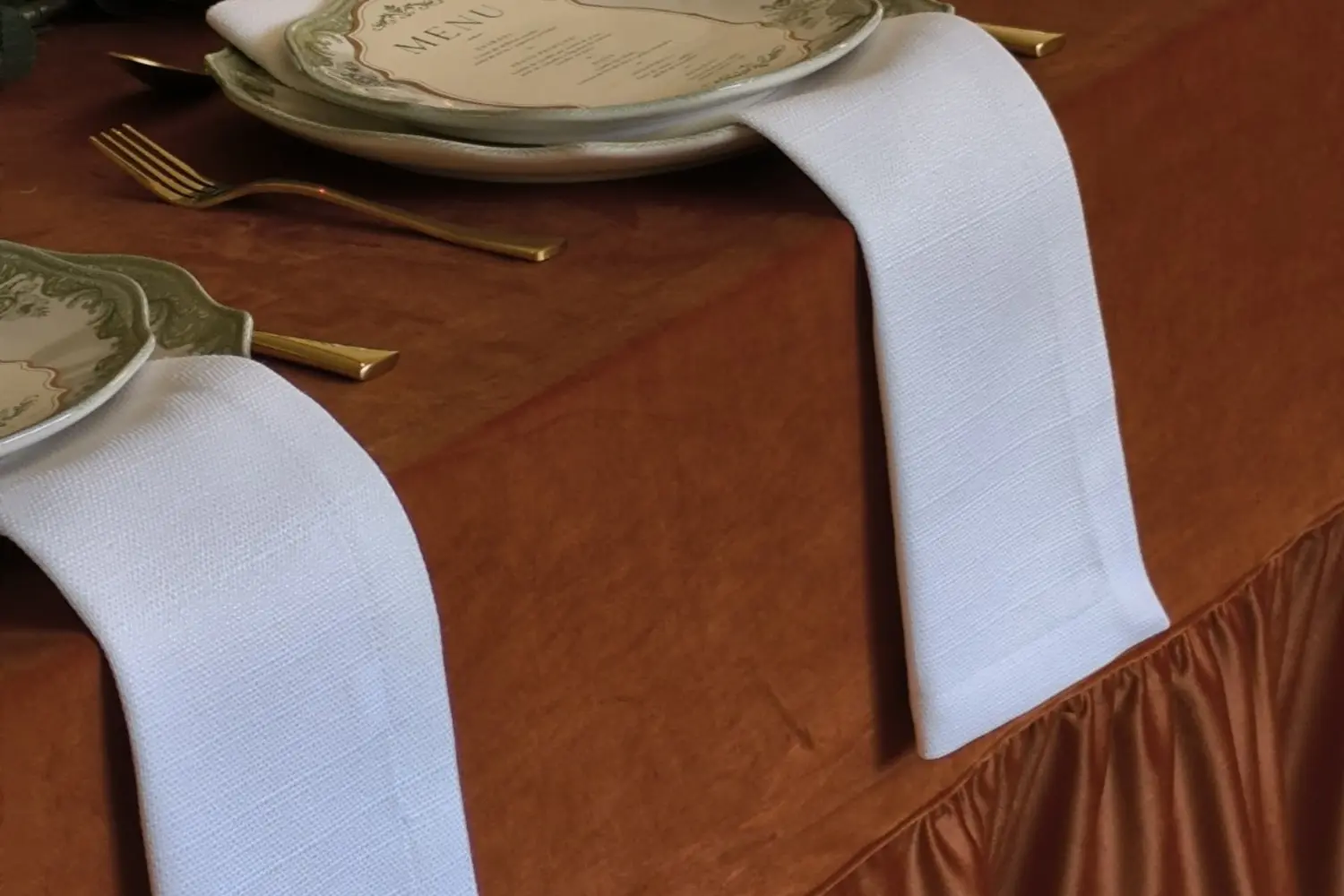 Guardanapos brancos numa mesa posta em tons terracota