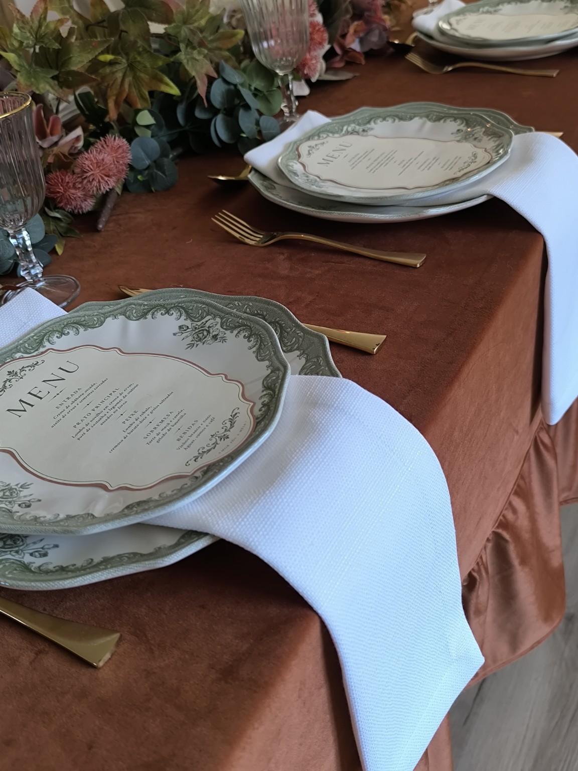 Pormenor de guardanapos brancos numa composição de mesa terracota
