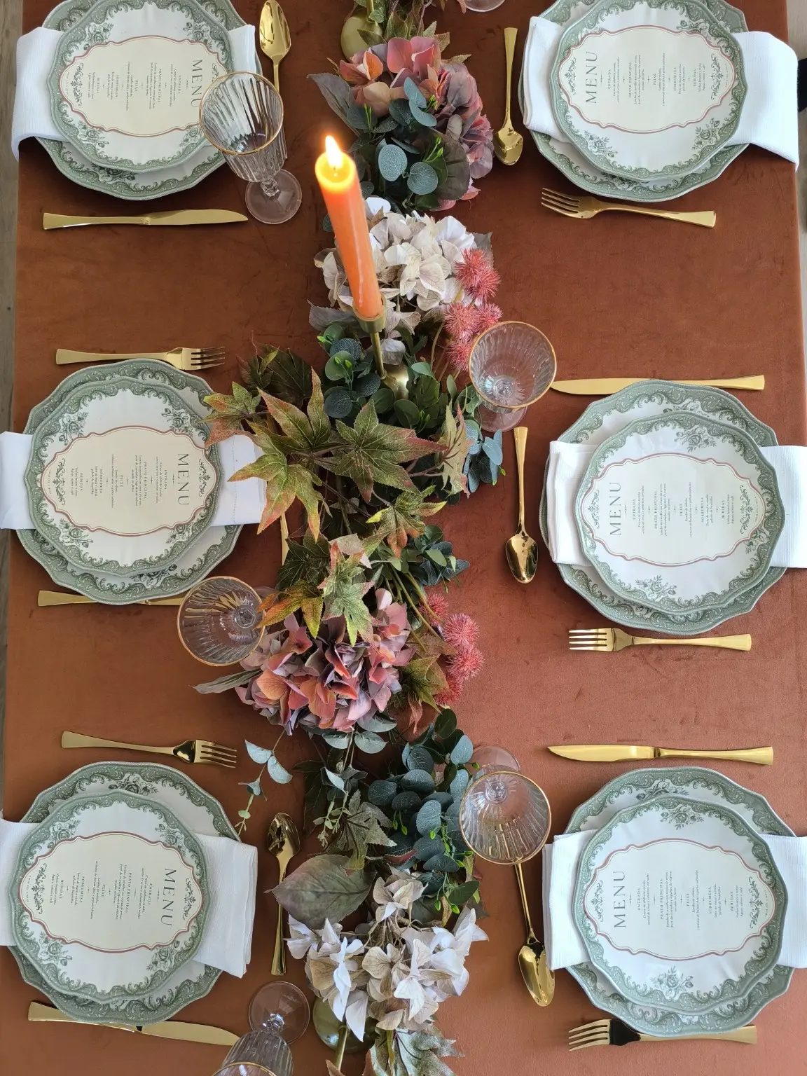 Vista superior da mesa em veludo terracota com composição floral de Outono